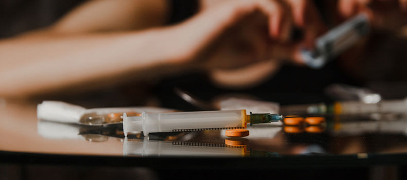 таблетки и шприц с наркотическим веществом для снятия ломки
