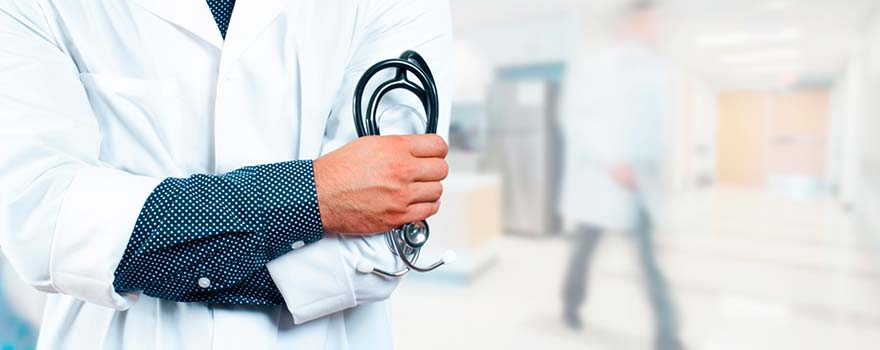 врач в больничном коридоре со стетоскопом в руке